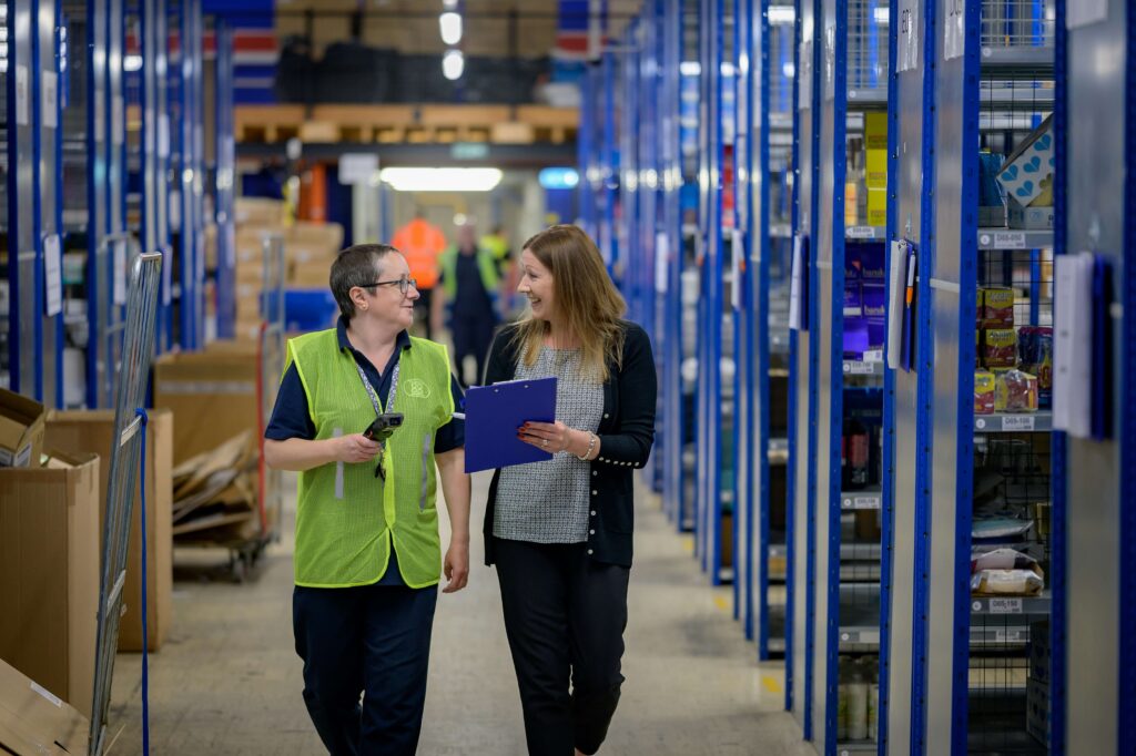 Two women in a warehouse calculating inventory turnover ratio