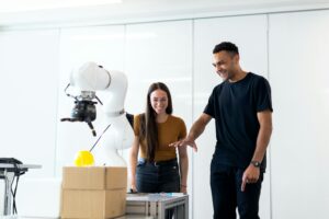 Two manufacturing engineers learning to use a cobot for manufacturing